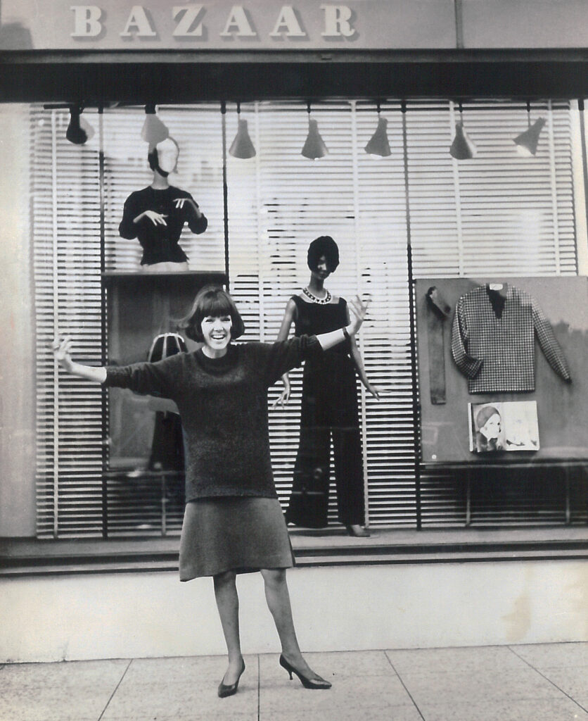 Foto in bianco e nero di Mary Quant d'avanti al suo negozio Bazaar